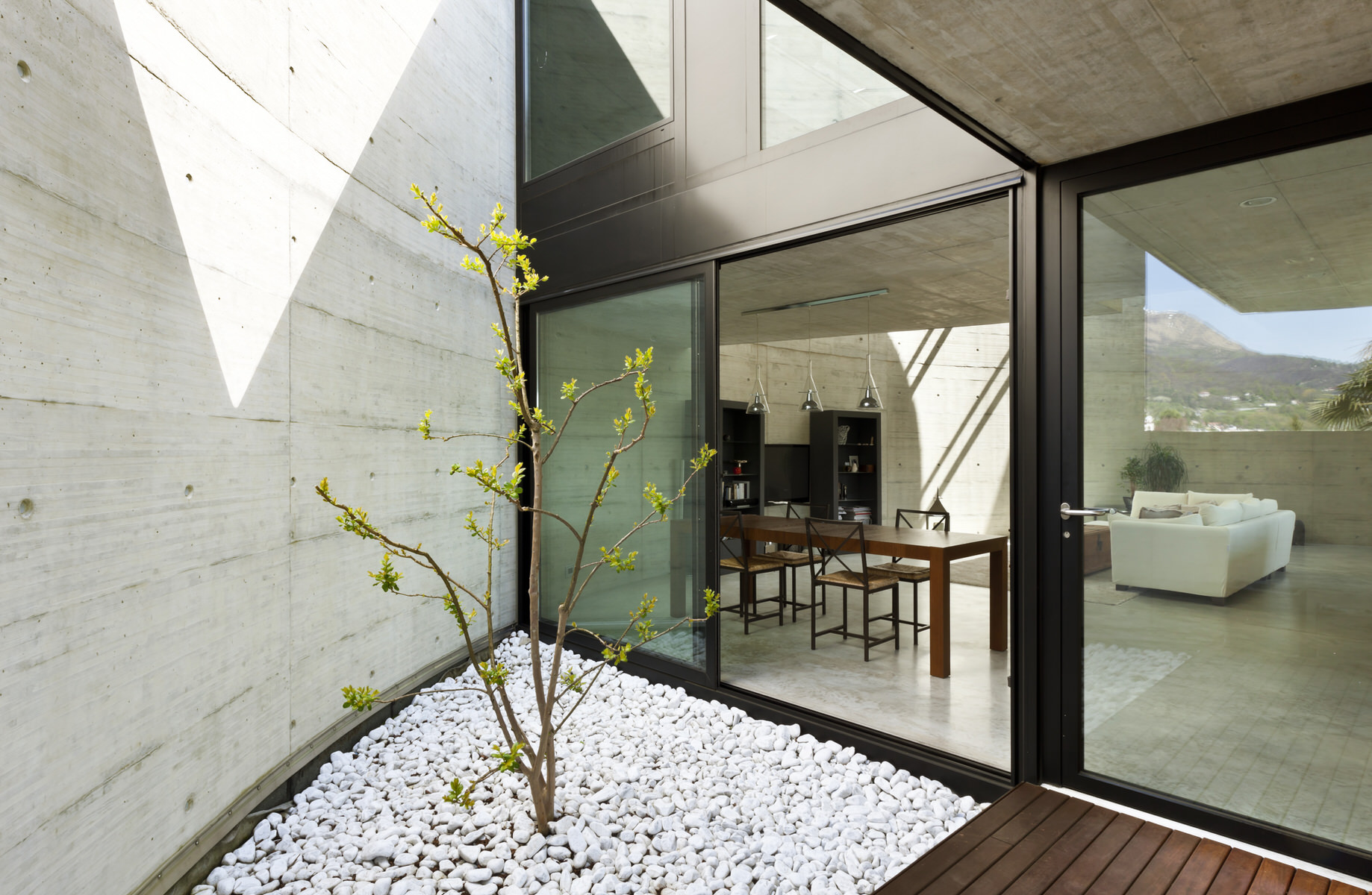 Architect-designed modern home featuring an open courtyard, glass walls, and minimalist concrete architecture, enhancing natural light and indoor-outdoor flow.