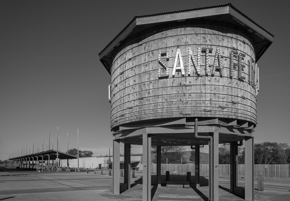 Iconic Santa Fe wooden water tower with bold lettering, captured in black and white, symbolizing the city's rich historical and architectural heritage.