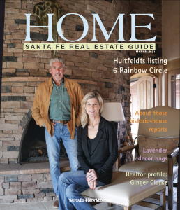 Architectural design features with a couple in front of a stone fireplace, featured in Santa Fe Real Estate Guide March 2017.