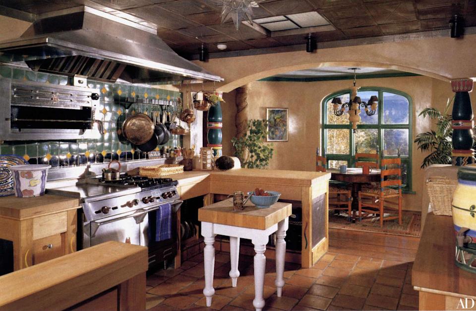 Bright and inviting kitchen with green tiled backsplash, wooden cabinetry, and a central island, offering a warm, homely feel with natural light.