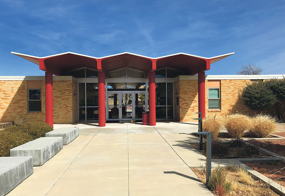 Mid-century modern building entrance with architect-designed angular red canopy, showcasing innovative design and functional aesthetics in architecture.